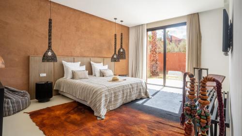 马拉喀什Villa M golf Amelkis à proximité的一间卧室设有一张床和一个大窗户