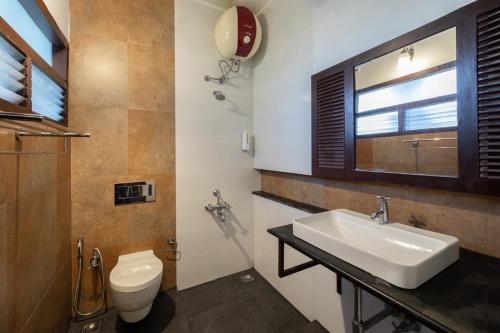 钦纳卡纳Avadale Munnar (Stag Groups Not Allowed)的一间带水槽和卫生间的浴室以及窗户。