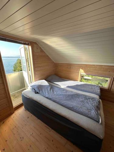 Exclusive panorama view of the Oslofjord的一个小房间的一个床位,设有窗户