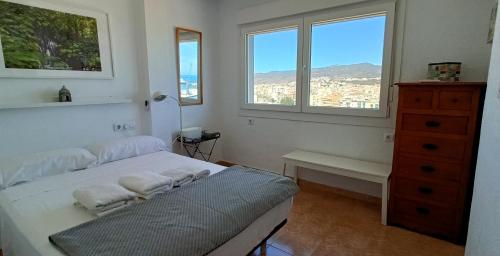 马拉加Mirador de Málaga的一间卧室配有一张床、一个梳妆台和两个窗户。
