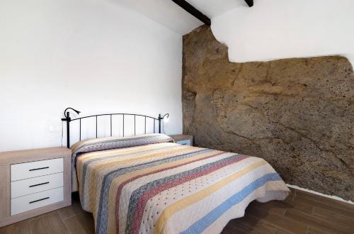 圣布里希达Casa Pepa的一间卧室设有一张床和石墙