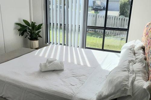 黄金海岸Kumera Home的窗前的白色床和毛巾