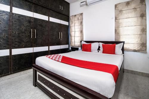 库卡特帕尔莱OYOFlagship Hillside Hotel Kukatpally的一间卧室配有一张带红色枕头的大床