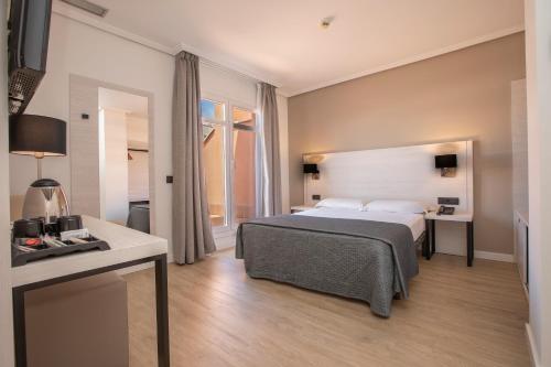 马德里Porcel Ganivet的配有一张床和一张书桌的酒店客房