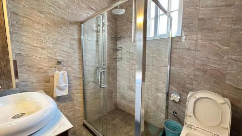 基加利White villa apartment的带淋浴、卫生间和盥洗盆的浴室