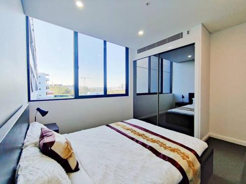 悉尼Sun-filled Apt w Stunning Open Views of Park&City的一间卧室设有两张床和两个大窗户