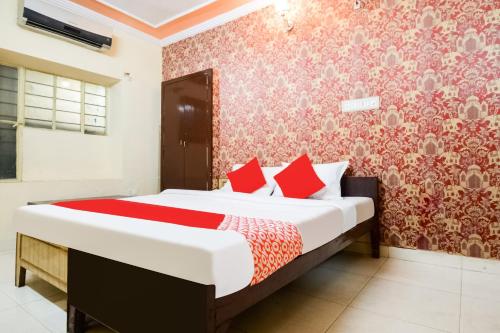 斋浦尔Collection O Hotel Rajwada Palace的一间卧室配有一张带红色枕头的大床