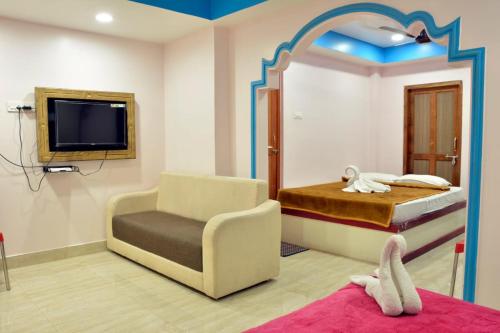 布莱尔港Sree Karpagam Dreams的一间卧室配有一张床、一把椅子和电视。