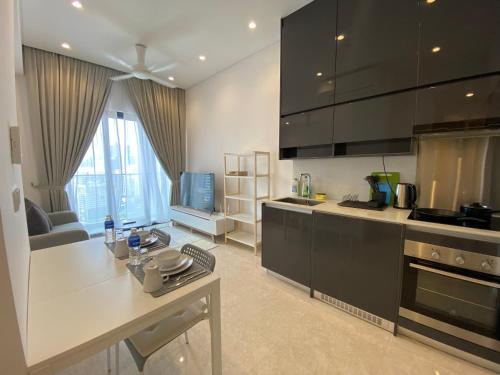吉隆坡Lalaport Suites At Lucentia Bukit Bintang City Center的厨房配有黑色橱柜和白色台面