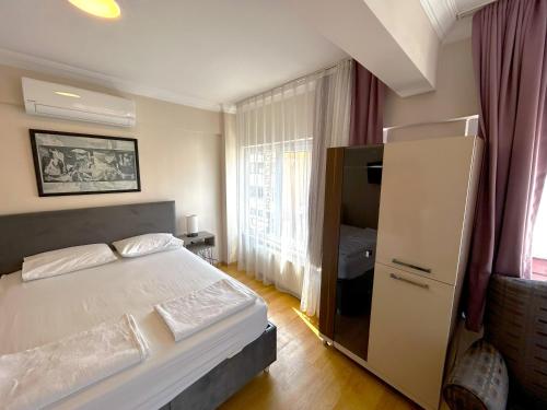 伊斯坦布尔Meydan Otel Uskudar的卧室设有白色的床和大窗户