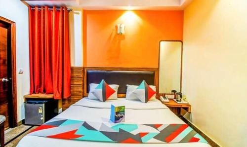 新德里FabExpress JP Palace的一间卧室配有一张带橙色墙壁的大床