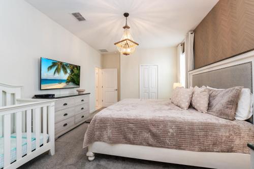 基西米Spacious 8BR Villa by Disney World w Private Pool的一间白色卧室,配有一张床和一张婴儿床