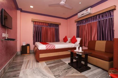 JādabpurOYO Flagship Rainbow Guest House的酒店客房,配有床和沙发
