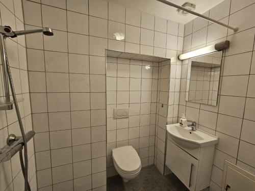 奥斯陆Grünerløkka Deluxe Apartments的白色瓷砖浴室设有卫生间和水槽