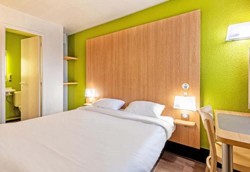 布雷斯特B&B HOTEL Brest Kergaradec Aéroport Gouesnou的一间设有一张白色大床的卧室,位于带绿色墙壁的房间