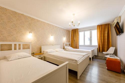 阿拉德贝拉酒店的酒店客房设有三张床和窗户。