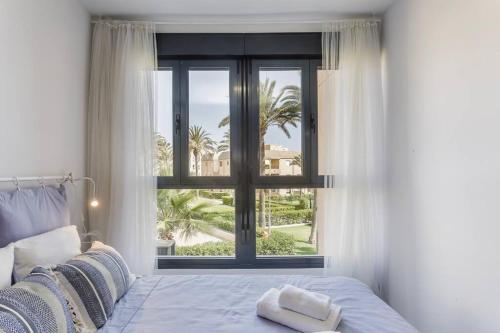 雷塔马尔Apto. primera línea playa, Retamar, Cabo de Gata (1º)的一间卧室设有一张床和一个美景窗户。