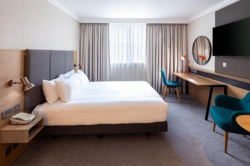 海维康Holiday Inn High Wycombe M40, Jct.4, an IHG Hotel的配有一张床和一张书桌的酒店客房