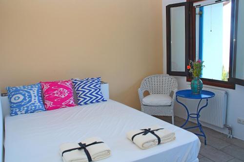 卡尔利拉基塔索斯拉达诺斯公寓的卧室配有床、椅子和窗户。