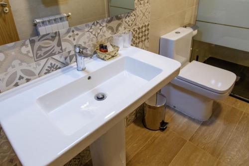 萨里亚卡萨巴兰宾馆的浴室配有白色水槽和卫生间。