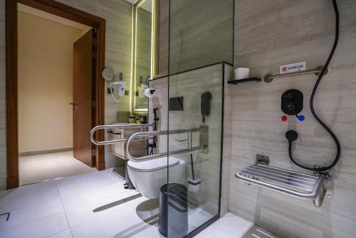 利雅德فندق فيفيان بارك الرائد Vivian Park El Raeid Hotel的一间带卫生间的浴室和墙上的一部电话