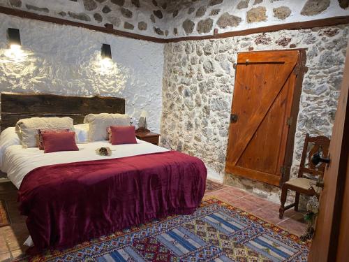 TanqueCASA MARA Casa Rural con terraza, barbacoa y vistas al Teide的一间卧室配有一张床和一扇木门