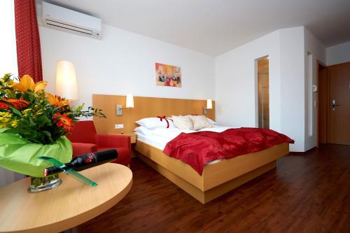 默德林默德林城市酒店的酒店客房,配有一张床和一张红色的沙发