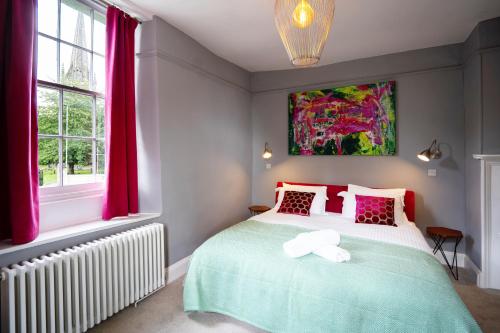 埃文河畔布拉德福The Castle Inn Bradford on Avon的卧室配有一张床,墙上挂有绘画作品
