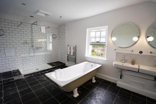埃文河畔布拉德福The Castle Inn Bradford on Avon的白色的浴室设有浴缸和水槽。