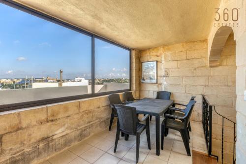 拉巴特A 3BR characteristic home in Rabat with lovely views by 360 Estates的一间带桌椅和大窗户的用餐室