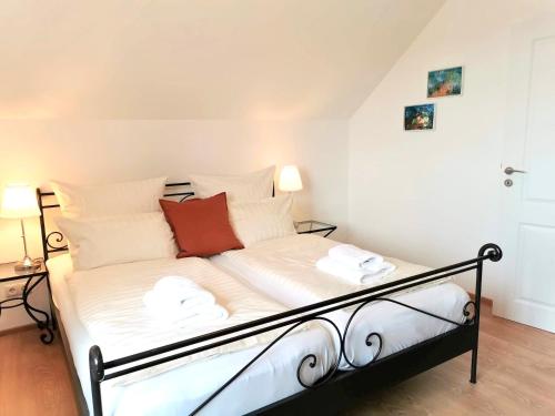 瓦瑟堡Landhaus Vogel - helle und lichtdurchflutete Maisonette-Ferienwohnung的一张带白色床单和红色枕头的床