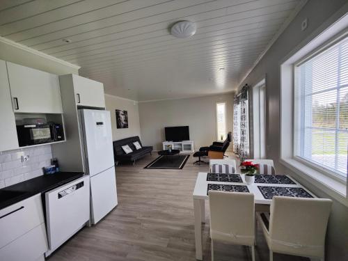 NärpiöANDY - Perfect location in the heart of Närpes 75 m2 - Sauna - Built in 2023的厨房以及带桌椅的起居室。