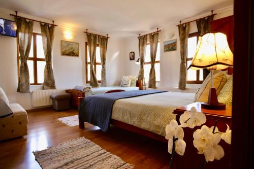 卡洛费尔伊利科瓦旅馆的一间卧室配有一张带灯和鲜花的床