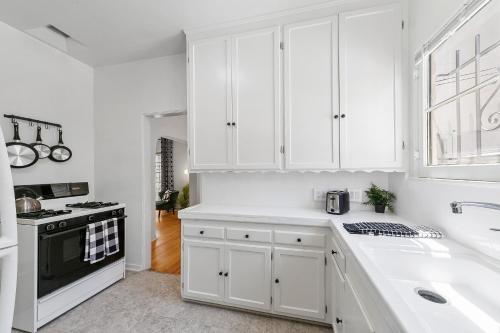 洛杉矶Beverly Hills Stylish & Central 1 BR Apt + Parking的白色的厨房设有水槽和炉灶。