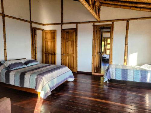 PácoraLA MARQUESA PACORA的一间卧室设有两张床,铺有木地板