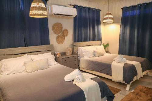 卡沃罗霍Casa Arrecife 28的卧室内的两张床,带蓝色窗帘