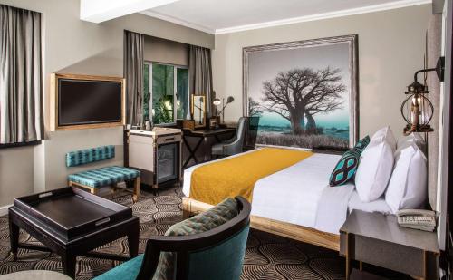 卢萨卡Southern Sun Ridgeway Lusaka的酒店客房设有一张大床和一张书桌。
