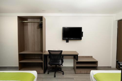 埃莫西约布吉姆比利亚酒店的客房设有书桌和墙上的电视。