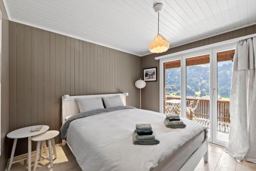 英格堡Sunny Design Chalet in Engelberg with spectacular view on Mount Titlis的一间带大床的卧室和一个阳台