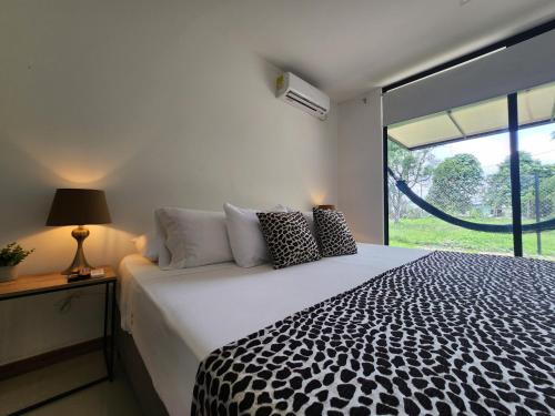 莱蒂西亚Amazonia Deluxe Lake Condo的卧室配有一张黑白床和窗户
