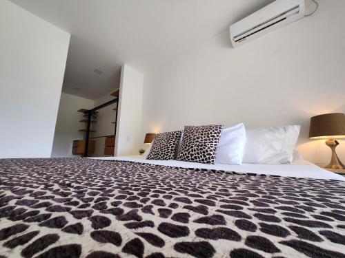 莱蒂西亚Amazonia Deluxe Lake Condo的一间卧室配有一张带黑白色棉被的床