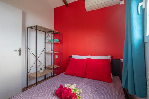 圣玛丽2 Bungalows avec Piscine et Evènements autorisés的红色的卧室,配有一张红色墙壁的床