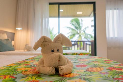 嘎林海斯港Marulhos Suítes Resort by MAI的一只塞满食物的兔子坐在床上
