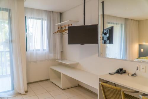 嘎林海斯港Marulhos Suítes Resort by MAI的客房设有书桌、镜子和水槽