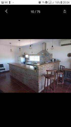 圣安东尼奥德阿雷科El retiro, casa de campo的厨房配有柜台和桌椅