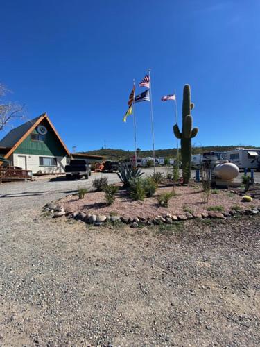 Black Canyon CityBlack Canyon Campground And Cabins的双旗和仙人掌的景观