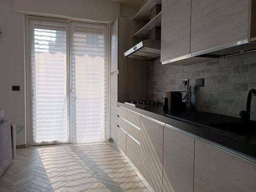 瓦拉泽GF Holiday Suite的厨房配有白色橱柜和大型滑动玻璃门