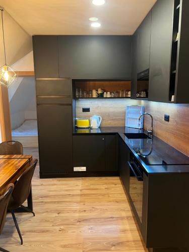 多纳瓦利Apartman Horec 30 a 1的厨房配有黑色橱柜和木桌
