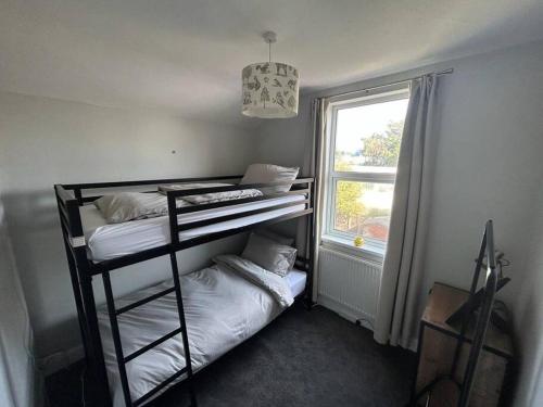 伊普斯威奇Entire 3 Bed House in Ipswich的客房设有两张双层床和一扇窗户。