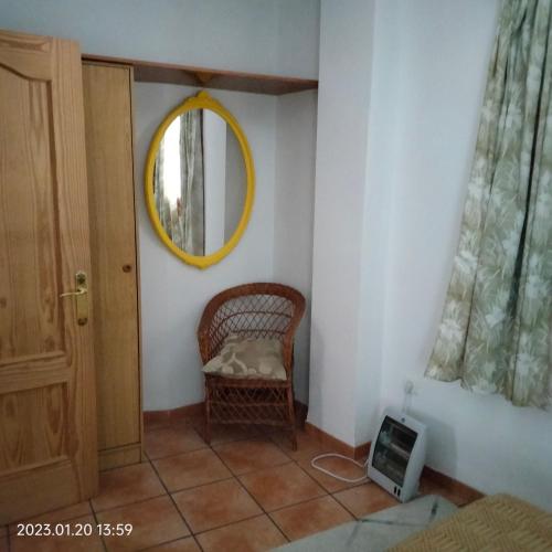 拉洛勒斯Apartamento vacacional en la Alpujarra的一间设有柳条椅和镜子的客房